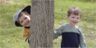 Jonathan & Robert peek from behind a tree