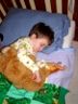 Robert sleeps with his Teddy bear and his Velociraptor